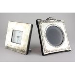 A modern silver photo frame of square form with embossed floral decoration,