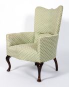 An armchair upholstered in pale green Art Deco patterned fabric,
