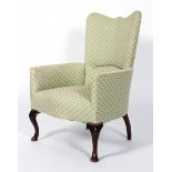 An armchair upholstered in pale green Art Deco patterned fabric,