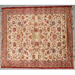 A 20th century wool Persian style rug, with scrolling leaves and flowers,