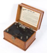 An Ericsson crystal set, with sweep tuning dial and detector, in hinged oak case,