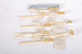 A collection of bone toothbrushes, of varying shapes including V form and semi circular,
