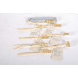 A collection of bone toothbrushes, of varying shapes including V form and semi circular,