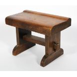 A substantial elm stool, the shaped seat on plinth supports and sleigh feet, 45cm high, 61cm wide,