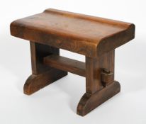 A substantial elm stool, the shaped seat on plinth supports and sleigh feet, 45cm high, 61cm wide,