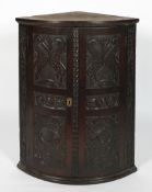 A Victorian carved oak corner cabinet, late 18th century,