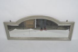 A bevelled mirror, of arched form, in a silvered frame, 66cm high,