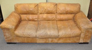 A large tan leather three seater sofa,