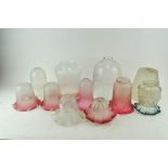 A collection of glass lamp shades, including shaded cranberry, vaseline and others,