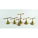 A group of six brass Glover & Barnes (London) brass T-bar weights, in sizes, on bell-shaped bases,