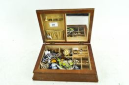 A wooden jewellery box containing assorted costume jewellery including rings and brooches