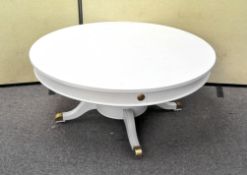 A large coffee table of circular form, raised on outswept leg,