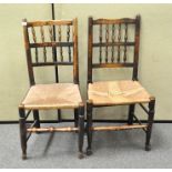 Two rush seated chairs with spindle backs and turned stretchers,