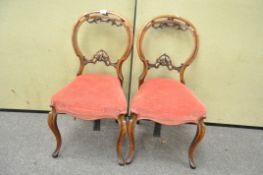 A pair of Victorian walnut balloon back dining chairs,