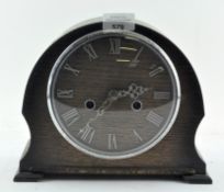 A mid century oak Smiths mantel clock, the dial with Roman numerals denoting hours,