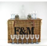 A Fortnum and Mason wicker basket, 42cm high x 64cm wide x 41cm deep; with 12 wine glasses,