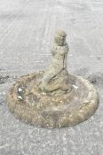 A cast stone bird bath with finial in the form of a mermaid,