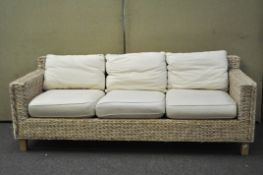 A three piece set of conservatory furniture, retailed by Next, comprising a sofa and two seats,