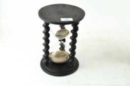 A sand timer with barley twist supports,