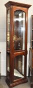 A modern tall glazed display cabinet, with bevelled glazed panels and adjustable shelves,