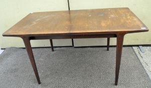 A Wrighton 1960's extending dining table of bowed rectangular form raised on tapering legs,
