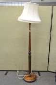 A turned oak standard lamp on a circular foot,