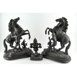 A pair of bronzed metal Marley horse sculptures, each raised upon wooden bases,