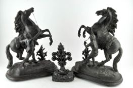 A pair of bronzed metal Marley horse sculptures, each raised upon wooden bases,