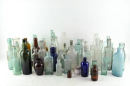 A large collection of glass medicine bottles of various shapes,