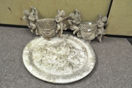 A cast wall plaque and pair of similar wall pockets,