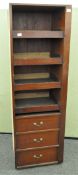 A mahogany veneered mid-section wardrobe having shelves above three drawers,