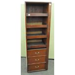 A mahogany veneered mid-section wardrobe having shelves above three drawers,