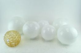 A collection of six milk glass globe shape light shades and another in pale gold (7)