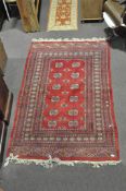 A Turkmen style rug, 240cm x 155cm; together with a small Indian rug,