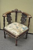 A carved oak corner chair, 19th century, with scrolling foliate decoration,