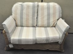 A modern wicker two seat sofa, with six cushions,