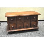 A wooden eight drawer table top spice cabinet,