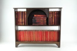 A miniature bookshelf containing a collection of leather bound and cloth bound books,