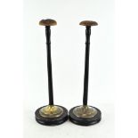 A pair of wig stands, with circular feet,