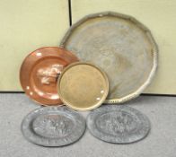 A large Indian brass charger, another smaller, a copper charger and a pair of oval bronzed plaques,