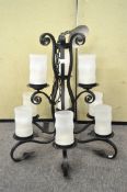 A large wrought iron nine branch chandelier, with frosted glass shades,