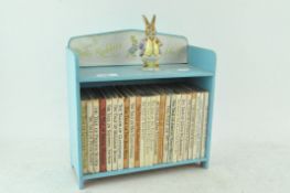 A Peter Rabbit book shelf, together with related books, 28cm wide,