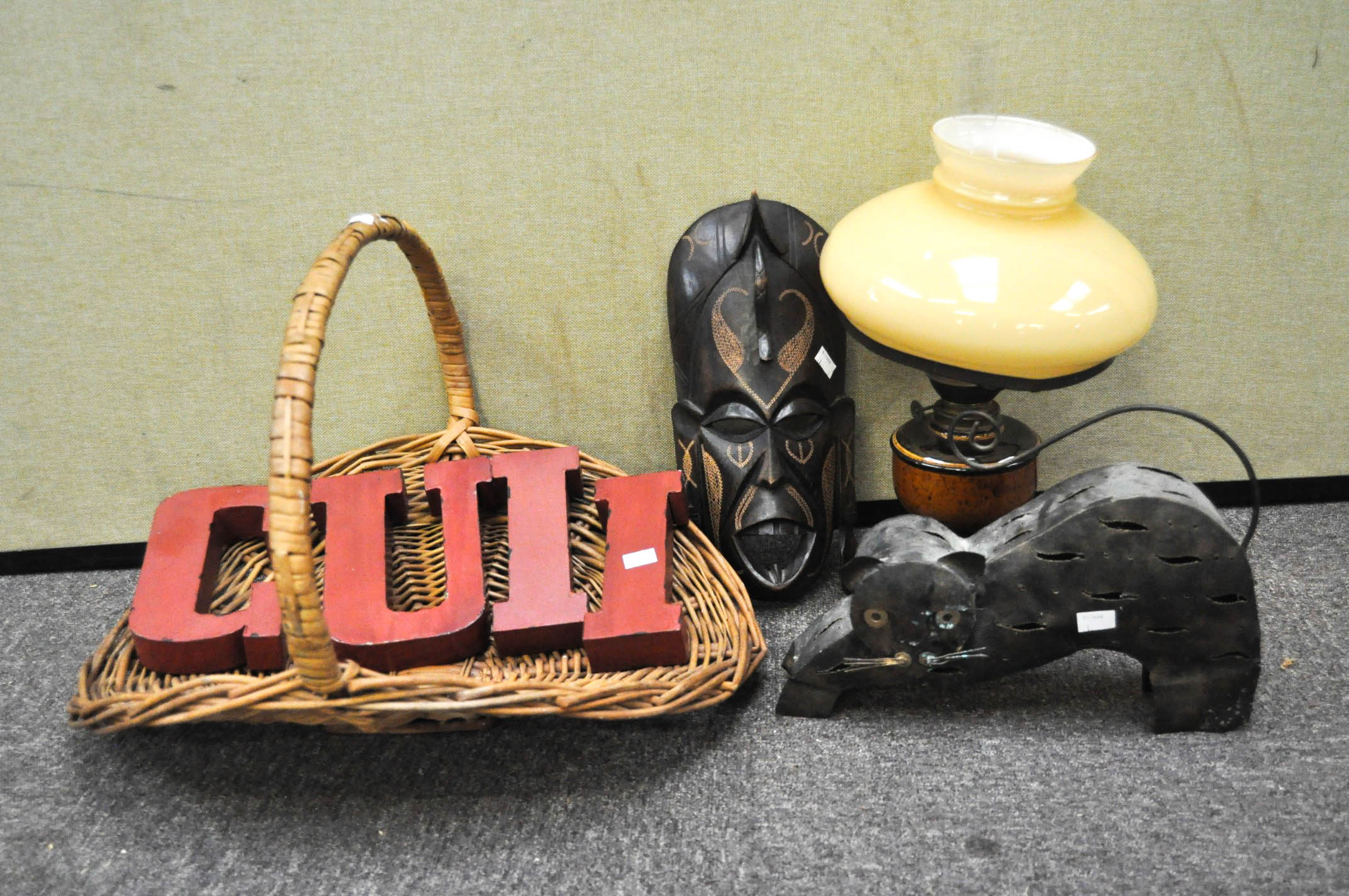 An assortment of collectables, including a tribal mask, wicker picnic basket,