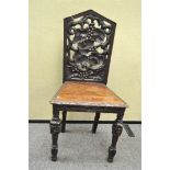 An oak hall chair, the back pierced with fruiting vines,