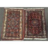 Two Pakistan wool prayer rugs, with red, black, green and cream geometric design,