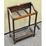 An Edwardian oak stick stand, with three compartments above a metal tray,