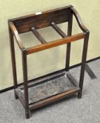 An Edwardian oak stick stand, with three compartments above a metal tray,