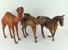 Three leather figures of animals, including two camels and a horse,