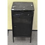 A black painted metal storage cabinet, comprising single drawer over a single door cupboard,