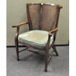 An early 20th century Oak and Bergere armchair by B Maggs & Co, Bristol,